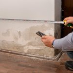 Messung der Wandfeuchtigkeit mit Feuchtigkeitsmessgerät zur Diagnose aufsteigender Feuchtigkeit