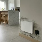 Heizkörper an feuchter Wand mit Schimmelspuren in modernem Wohnraum