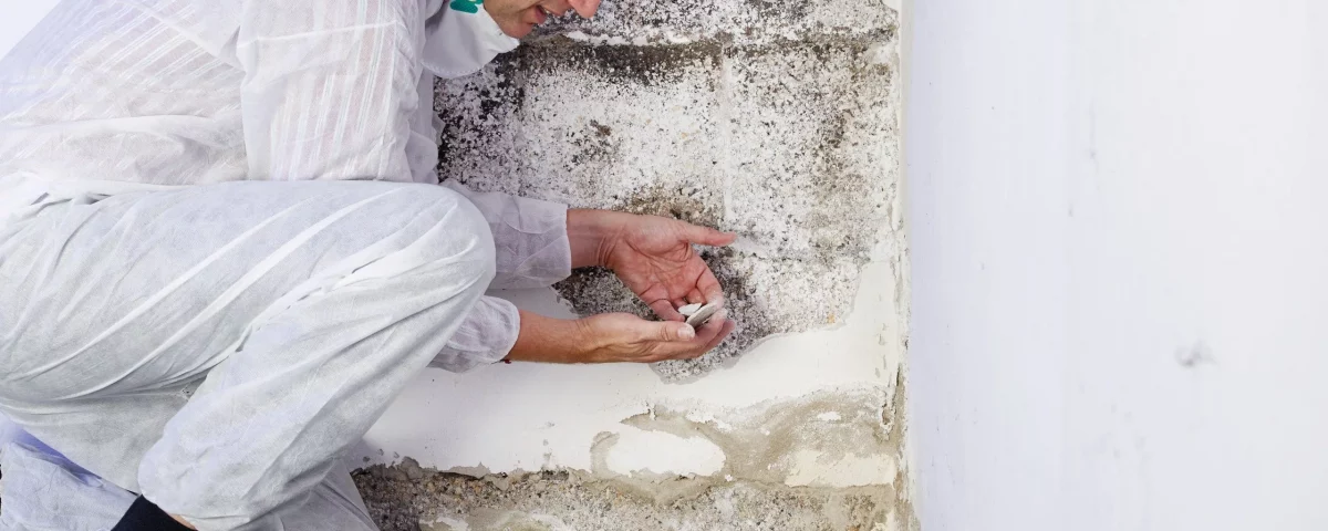 Fachmann inspiziert Wand mit Salpeter und aufsteigender Feuchtigkeit – Feuchtigkeitsschäden durch Kapillarfeuchtigkeit