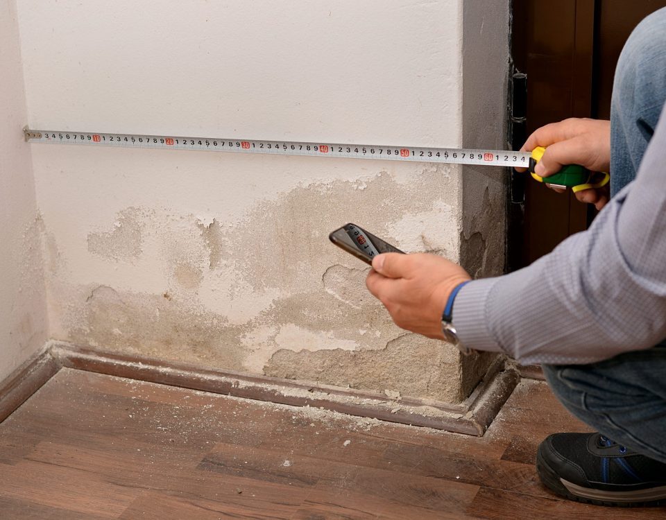 Messung der Wandfeuchtigkeit mit Feuchtigkeitsmessgerät zur Diagnose aufsteigender Feuchtigkeit