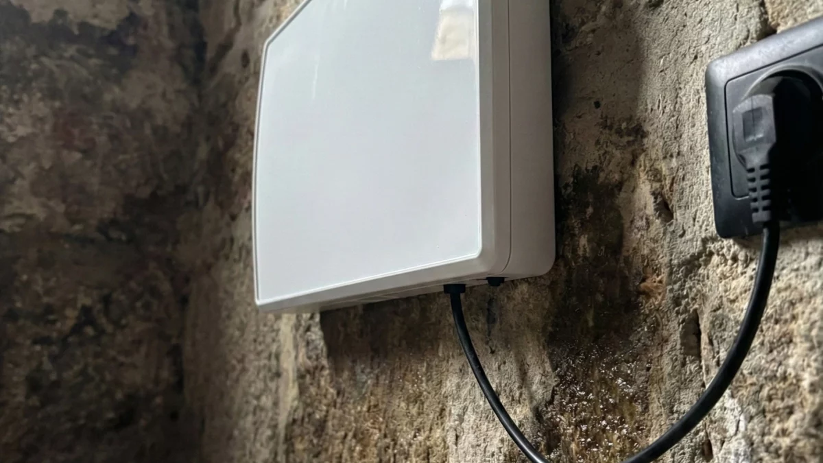 Weißes Gerät an stark geschädigter Wand mit extremen Feuchtigkeitsspuren